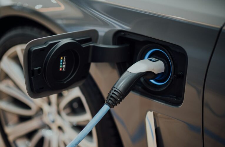 Comunicado de prensa DIAN 127 del 01-10-2026. IVA. Devoluciones por compra de vehículos híbridos y eléctricos. 24 Cable de carga conectado a un vehículo eléctrico