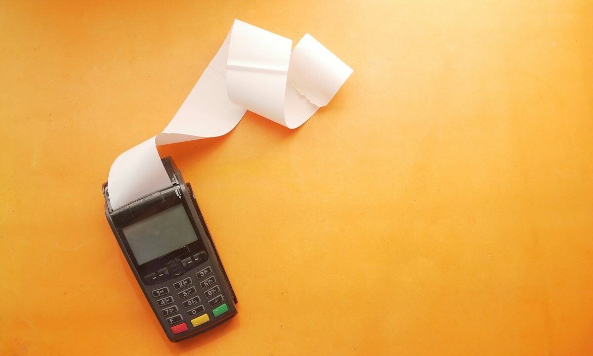 Concepto 015505 del 04-09-2026. Régimen SIMPLE. Descuento de aportes a pensiones y de pagos electrónicos. 28 Datáfono con recibo sobre fondo naranja
